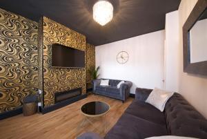 een woonkamer met een bank en een tv bij Ideal Abode Leonard chester in Chester