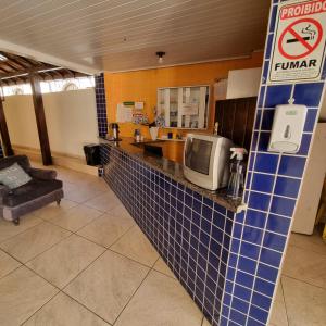 a kitchen with a tile counter with a tv on it at Pousada do Sul in Ilhéus