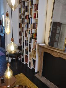 un salon avec une cheminée et un mur de livres dans l'établissement Chantilly Townhouse, à Gand
