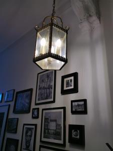 a chandelier hanging over a wall with pictures at Chantilly Townhouse in Ghent