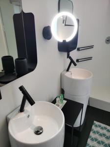 ein Badezimmer mit einem Waschbecken und einer Uhr an der Wand in der Unterkunft Chantilly Townhouse in Gent
