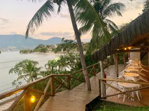 a deck with chairs and a view of the water at Pontal das Marinas Frente Ilhabela in São Sebastião