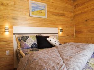 a bedroom with a bed in a room with wooden walls at Quinta dos Ventos Chalé in Urubici +26 photos