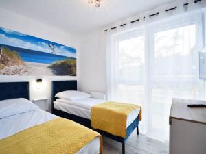 pokój hotelowy z dwoma łóżkami i oknem w obiekcie Apartament Navy Blue w Dziwnówku