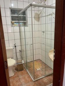 La salle de bains est pourvue de toilettes et d'une cabine de douche en verre. dans l'établissement Casa em Ibitipoca - 7 pessoas, à Lima Duarte