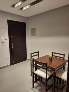 Un comedor con mesa y sillas de madera. en Madinaty 2, en Madīnat ash Shurūq