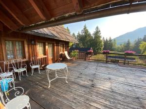 a deck with chairs and a table on a cabin at AGRITURISMO FARE BIO in Tarvisio