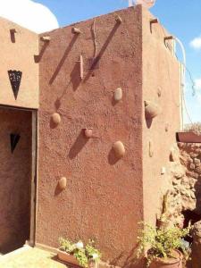 een bakstenen gebouw met een klok aan de zijkant bij berber house in Taourirt