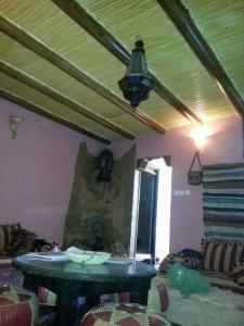 een woonkamer met een tafel en een plafond bij berber house in Taourirt