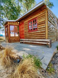 a log cabin with a red door at Hotel Juanita in Puelches