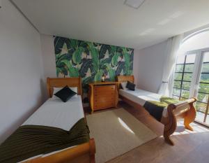 a room with two beds and a window at Vila Pugliesi Hotel Boutique in Lençóis