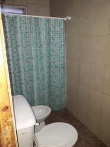 ein Badezimmer mit 2 WCs und einem Duschvorhang in der Unterkunft Casa céntrica en San Rafael in San Rafael