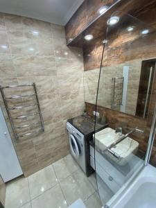 a bathroom with a sink and a washing machine at DendrariumParkApartments in Chişinău
