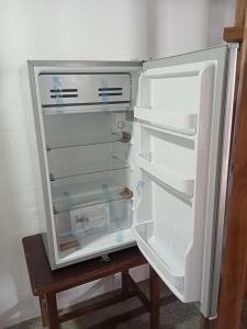 an empty refrigerator with its door open on a table at Cabañas El Manglar in Las Tunas