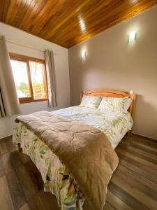 1 dormitorio con 1 cama con techo de madera en Meu Cantinho Serrano, en Urubici