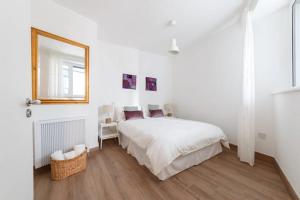 een witte slaapkamer met een bed en een spiegel bij Stylish Soundproof Temple Bar Square in Dublin