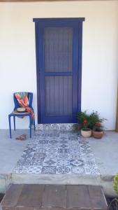 a blue door on a white building with potted plants at Aldeia Corumbau in Corumbau