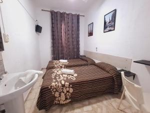 a small bathroom with a bed and a sink at Pensión Rivera in Madrid