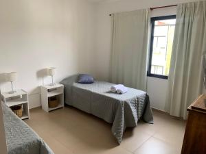 a small bedroom with a bed and a window at Solar del Río in Concepción del Uruguay