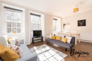 a living room with a couch and a tv at Bright New Town 2BR-1BA, 1 min to George St - Free Parking by Bonjour Residences Edinburgh in Edinburgh