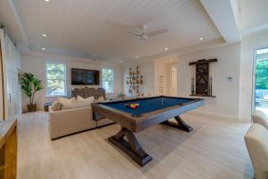 uma sala de estar com uma mesa de bilhar em Makana Pool House home em Princeville