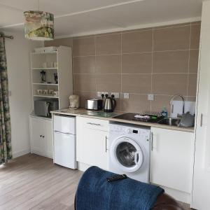 een keuken met een wasmachine en een wastafel bij North Muasdale Farm in Muasdale