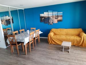 uma sala de estar com um sofá, uma mesa e cadeiras em Magnifique appartement face à la mer !! Résidence Charmette em Saint-Hilaire-de-Riez