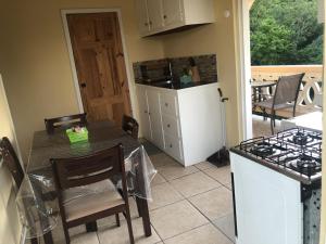 a kitchen with a table and a stove top oven at Caribbean Dream Vacation Property CD3 in Rodney Bay Village