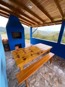 un tavolo in legno in una stanza con camino di Meu Cantinho Serrano a Urubici