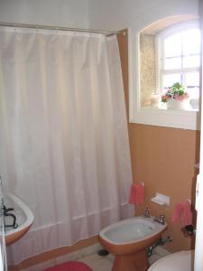 baño con cortina de ducha blanca y lavamanos en Casa de São João en Viana do Castelo