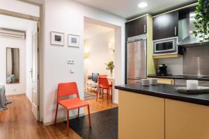 a kitchen with orange chairs and a counter top at Fabuloso apartamento - Prado Museum in Madrid