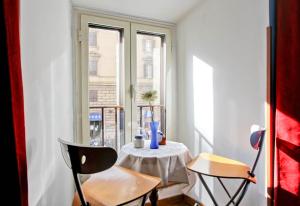 ローマにあるRoman Houseのテーブルと窓が備わる小さな客室です。
