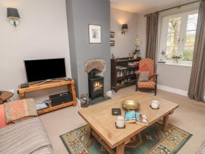 a living room with a table and a fireplace at Carwood in Dufton