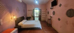 um pequeno quarto com uma cama e uma janela em Imbassaí Pousada Hostel Lujimba em Imbassaí