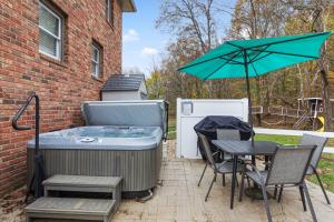 a hot tub with a table and chairs and an umbrella at Executive 4bdr Country Getaway-Bachelor(ette) Wedding Parties Welcome in Nashville