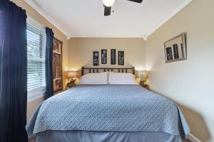 a bedroom with a bed with a blue comforter and a window at Brenda Lee History 4BR Retreat Pool Hot Tub in Nashville +87 photos