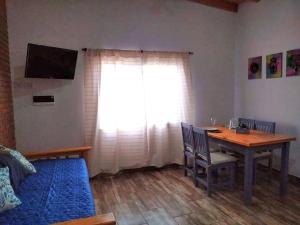 a living room with a dining room table and a window at Cabañas Tierra del Sol in Las Rabonas