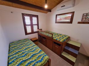 um quarto com 2 camas e 2 janelas em Casa na Beira do Mar, Peroba, Icapuí/CE, Morada Mariana em Icapuí
