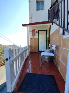 Un balcón de una casa con una escalera y una puerta en El Rincón del Senderista en Santa Cruz de Tenerife