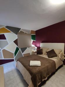 a bedroom with a large bed with a colorful wall at El Rincón del Senderista in Santa Cruz de Tenerife