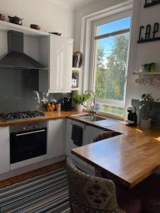 uma cozinha com uma mesa de madeira e uma bancada em Traditional apt close to city centre & Hampden em Glasgow