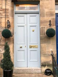 a white door on a house with a christmas tree at Traditional apt close to city centre & Hampden in Glasgow