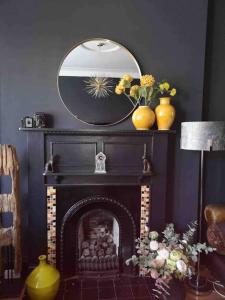sala de estar con chimenea y espejo en Traditional apt close to city centre & Hampden, en Glasgow