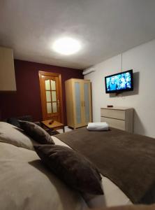 1 dormitorio con 1 cama grande y TV de pantalla plana en El Rincón del Senderista en Santa Cruz de Tenerife