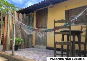 une chaise devant une maison avec une clôture dans l'établissement Pousada Trilha do Velho Chico, à Piranhas