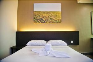 uma cama branca com um laço em cima em PADI PADI HOTEL em Kangar