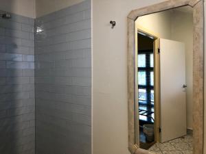 a bathroom with a mirror and a shower at Grey Gum Lodge in Nimbin