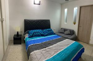 1 dormitorio con 1 cama grande y 1 sofá en Lindo Apartamento en Rodadero Santa Marta, en Santa Marta