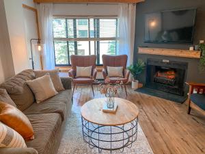 a living room with a couch and a table and a fireplace at Ski-In Ski-out Luxury Condo with Hot Tub and pools in Snowshoe