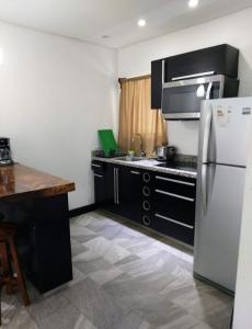 a kitchen with a white refrigerator and a counter at Pura vida apartments in Quepos